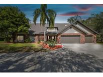 Charming brick home featuring a well-maintained yard, mature landscaping, and a spacious driveway at 1902 Sweet Bay Ct, Plant City, FL 33566