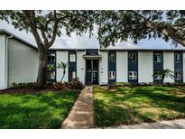 Well-maintained condo building with mature trees and green lawn, located at 3435 Cove Isle Dr #256, Tampa, FL at 256 Cypress Ln # 120, Oldsmar, FL 34677