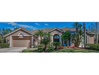 Beautiful home featuring lush landscaping, a barrel tile roof, and a two-car garage at 9101 Highland Ridge Way, Tampa, FL 33647