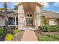 Inviting home entrance featuring double doors and manicured landscaping enhancing its curb appeal at 9405 Ashley Dr, Weeki Wachee, FL 34613