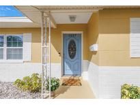 Inviting front entrance features a blue door with decorative glass and freshly painted white and yellow exterior at 6537 8Th N Ave, St Petersburg, FL 33710