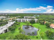 An aerial view of the condo community shows lush landscaping, a pond with fountain, and well-maintained buildings at 8174 Terrace Garden N Dr # 307, St Petersburg, FL 33709