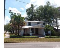 Inviting two-story home featuring a charming front porch, lush landscaping, and a classic architectural style at 1001 W Baker St, Plant City, FL 33563