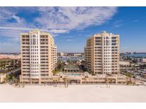 Stunning aerial view of beachfront condos featuring a pool and beautiful blue skies at 11 San Marco St # 807, Clearwater Beach, FL 33767