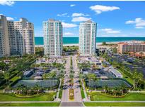 Beautiful aerial view of beachfront condos, tennis courts, and well-manicured landscaping on a sunny day at 1170 Gulf Blvd # 2001, Clearwater, FL 33767