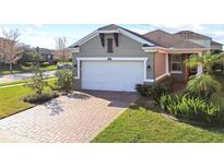 Charming single-Gathering home featuring a two-car garage, neatly landscaped front yard, and paver driveway at 17596 Terrazzo Way, Land O Lakes, FL 34638