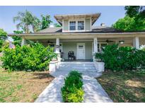 Charming two-story home boasts a welcoming front porch and lush landscaping at 602 Nw Drane St, Plant City, FL 33563