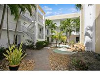 Inviting courtyard with lush landscaping, brick pathways and a serene water feature perfect for relaxing at 661 Poinsettia Ave # 307, Clearwater Beach, FL 33767