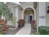 Inviting front entrance features an arched entryway, manicured landscaping, and a well-maintained facade at 11610 Griffith Park Ter, Bradenton, FL 34211