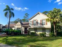 Charming two-story home with a well-maintained lawn, lush landscaping, and classic shuttered windows at 3712 Murray Dale Dr, Valrico, FL 33596