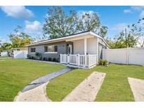 Charming single-story home with a well-maintained lawn, white picket fence, and inviting front entrance at 3907 Elkcam Se Blvd, St Petersburg, FL 33705
