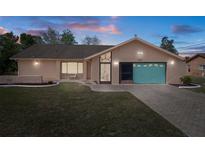 Charming single-story home with a well-maintained lawn, colorful garage door, and welcoming curb appeal at 5357 Kirkwood Ave, Spring Hill, FL 34608
