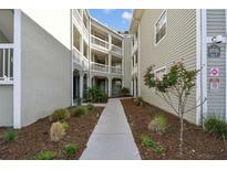 Beautiful condo complex featuring a landscaped walkway and private balconies at 6916 Stonesthrow N Cir # 9103, St Petersburg, FL 33710