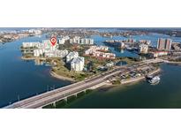Gorgeous aerial view of a waterfront property with white buildings, lush landscaping, and bridge access at 7902 Sailboat Key S Blvd # 206, South Pasadena, FL 33707