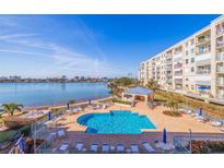 Beautiful outdoor pool and lounge area overlooking the ocean with condo building in the background at 7902 Sailboat Key S Blvd # 206, South Pasadena, FL 33707