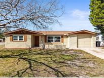 Charming single-Gathering home featuring a brick exterior, attached garage and well-maintained front yard at 10735 Manchester Rd, Port Richey, FL 34668