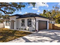 Charming home featuring a dark roof, a two-car garage, and a well-manicured lawn at 4006 N 27Th St, Tampa, FL 33610