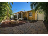 Charming yellow home with a fire pit and lush tropical landscaping creating an inviting outdoor space at 4710 22Nd N Ave, St Petersburg, FL 33713