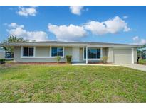 Charming single-story home featuring a well-maintained lawn, neutral exterior, and attached garage at 5043 Escalante Dr, North Port, FL 34287