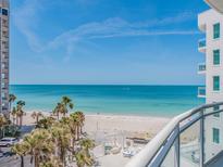 Expansive beach view from the condo balcony, overlooking white sands, turquoise water, and palm trees at 1590 Gulf Blvd # 501, Clearwater Beach, FL 33767