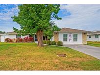Charming single-story home featuring a lush green lawn, stone accents, and a well-maintained landscape at 1782 Coconut Dr, Venice, FL 34293