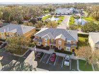 Aerial view of condo complex featuring mature landscaping and ample parking at 2044 Greenwood Valley Dr, Plant City, FL 33563