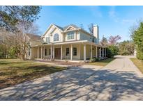 Inviting two-story home with a long porch and classic architectural details on a bright, sunny day at 6615 Ridge Top Dr, Trinity, FL 34655