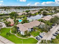 Wonderful aerial view of the condo community with pool, pond, and parking at 10263 Gandy N Blvd # 105, St Petersburg, FL 33702