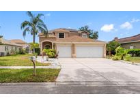Charming two-story home featuring a well-manicured lawn, lush landscaping, and a spacious two-car garage at 10904 Summerton Dr, Riverview, FL 33579