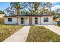 Charming single-story home featuring a well-maintained front yard with a classic walkway and light colored facade at 1125 Fairwood Ave, Clearwater, FL 33759