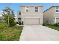 Charming two-story home featuring a neutral color palette, attached two-car garage, and well-manicured lawn at 16126 Sunday Stroll Way, Odessa, FL 33556