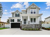 Stunning two-story home boasts a charming porch, gray siding, and a spacious two-car garage at 3404 S Omar Ave, Tampa, FL 33629