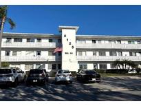 Multi-level condo with an American flag and parking lot at 8125 112Th St # 301, Seminole, FL 33772