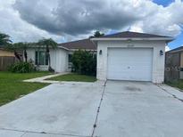 Charming single-story home featuring a well-maintained lawn, attached two-car garage, and inviting curb appeal at 12139 Buffington Ln, Riverview, FL 33579