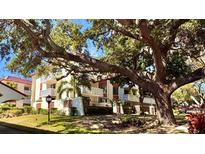 Beautiful multi-story condo with well-manicured landscaping and mature trees creating a serene environment at 2612 Pearce Dr # 211, Clearwater, FL 33764