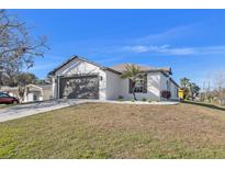 Charming single-story home showcasing a well-manicured lawn and a two-car garage at 6449 Woodland Ln, New Port Richey, FL 34653