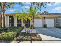 Charming home with a two-car garage, well-maintained landscaping, and lovely palm trees at 6906 Muncaster Ct, Tampa, FL 33625