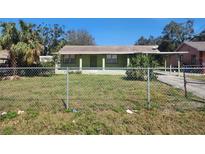 Charming single-story home featuring a front porch, large windows, and a lush green lawn, inviting curb appeal at 6935 W Mohawk Ave, Tampa, FL 33634