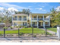Charming, bright yellow two-story home featuring dual balconies and a well-manicured front lawn at 732 Oak Ne St, St Petersburg, FL 33701