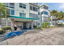 Inviting condo building featuring rock facade, well-manicured landscaping and an accessible entrance at 100 Waverly Way # 101, Clearwater, FL 33756