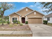 Charming one story home featuring a two car garage, neutral paint, and manicured landscaping at 10328 Celtic Ash Dr, Ruskin, FL 33573