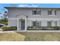 Charming two-story townhouse featuring a well-maintained lawn and gray shutters at 4049 Dolphin Dr, Tampa, FL 33617