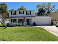 Charming two-story home with well-manicured lawn, blue door, and front porch with rocking chairs at 4912 W Dryad St, Tampa, FL 33629