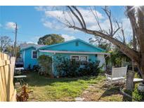 Quaint backyard featuring a charming bench and lush greenery under a partly cloudy sky at 5126 1St S Ave, St Petersburg, FL 33707