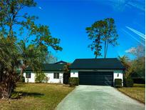 Charming single-story home featuring a two-car garage, a driveway, and a well-maintained lawn with mature trees at 5144 Pine Tree Ln, Wesley Chapel, FL 33543