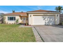 Charming single-story home showcasing a well-maintained lawn and attached two-car garage at 6818 123Rd Ave, Largo, FL 33773