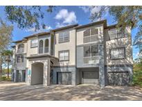 Condominium exterior with attached garages, balconies, and stucco walls at 13304 Sanctuary Cove Dr # 303, Temple Terrace, FL 33637