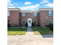 Charming red brick building featuring a classic white door and ample natural light from many windows at 1142 84Th N Ter # C, St Petersburg, FL 33702