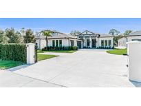 Beautiful exterior of a two-story white home with well-manicured lawn and a long, spacious driveway at 2007 Belleair Rd, Clearwater, FL 33764