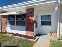 Charming single-story villa with a brick accent wall, white trim, and a well-maintained front yard at 250 Rosery Nw Rd # 329, Largo, FL 33770